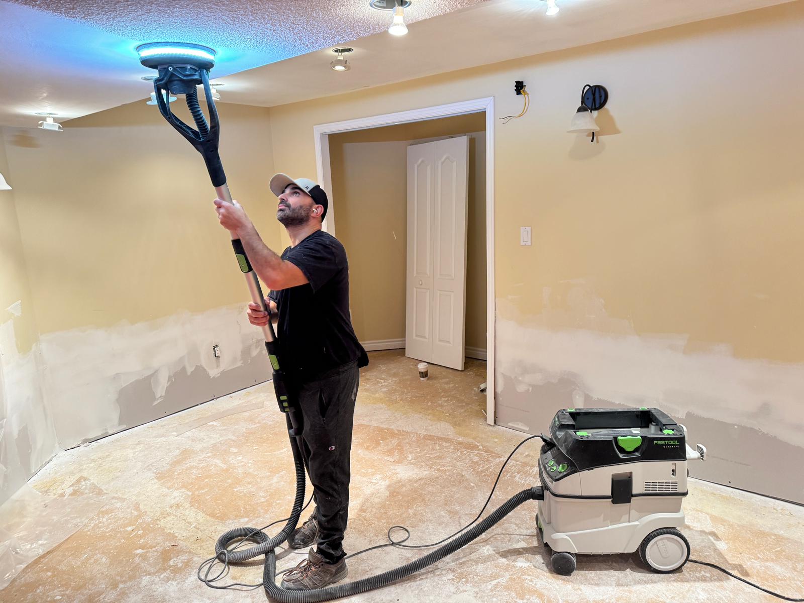 Fire damage restoration technician cleaning soot from a ceiling in Toronto using professional equipment — Restoration Professionals
