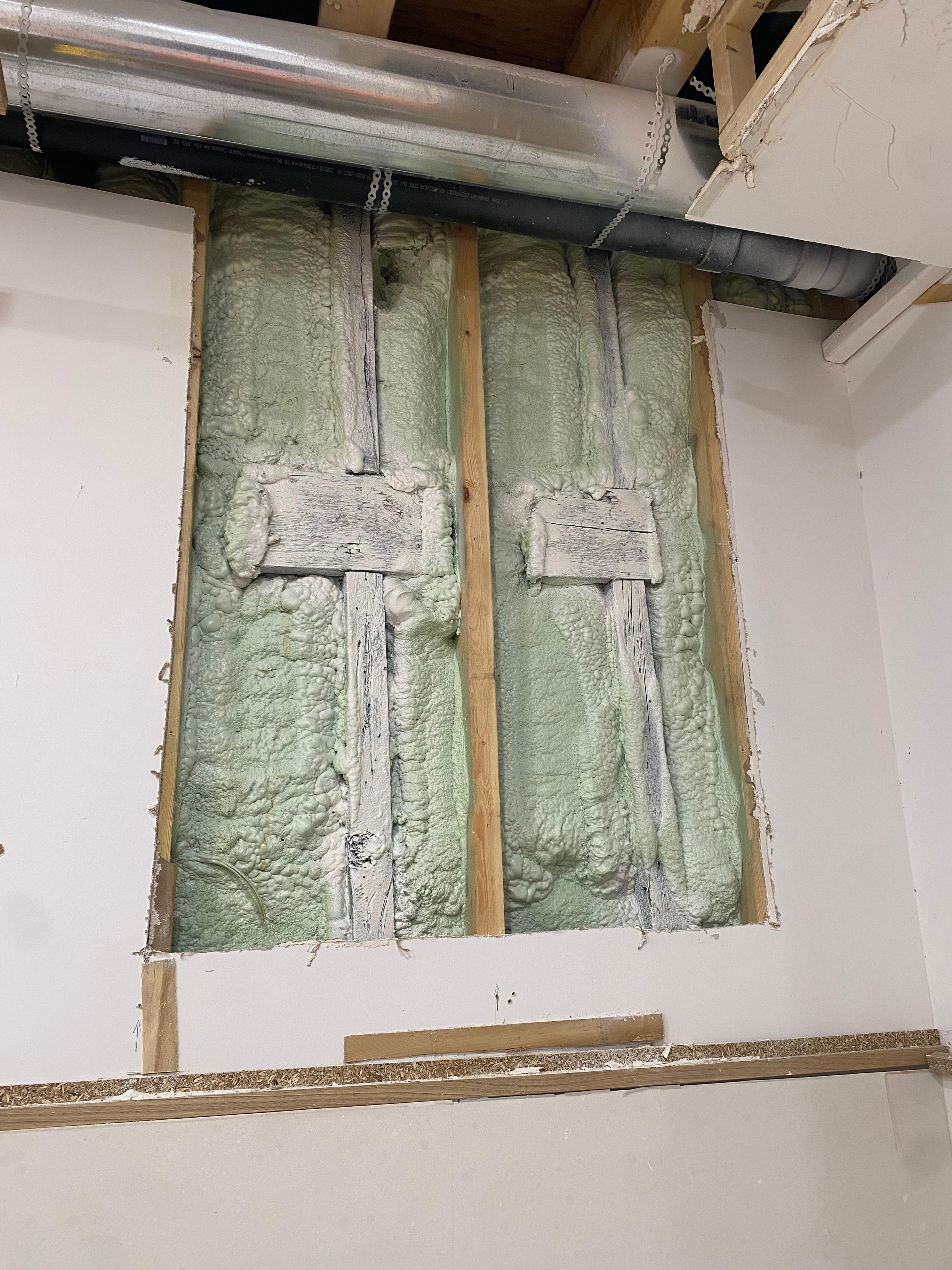 Spray foam insulation applied to exposed wall framing during structural restoration after fire damage in Toronto — Restoration Professionals