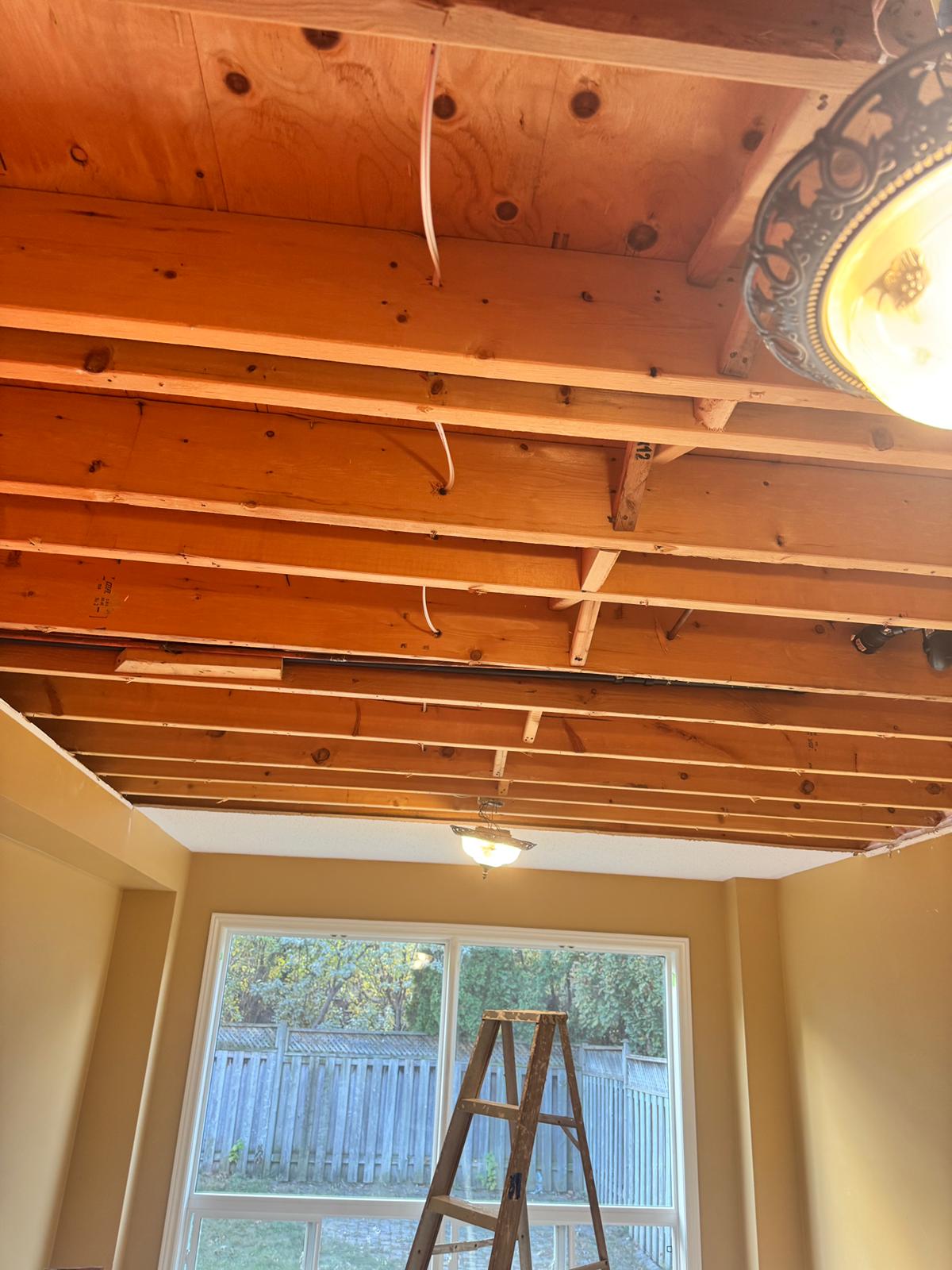 Water-damaged ceiling drywall removed exposing joists in a Toronto home — ceiling removal is a critical step in flood restoration and mold prevention