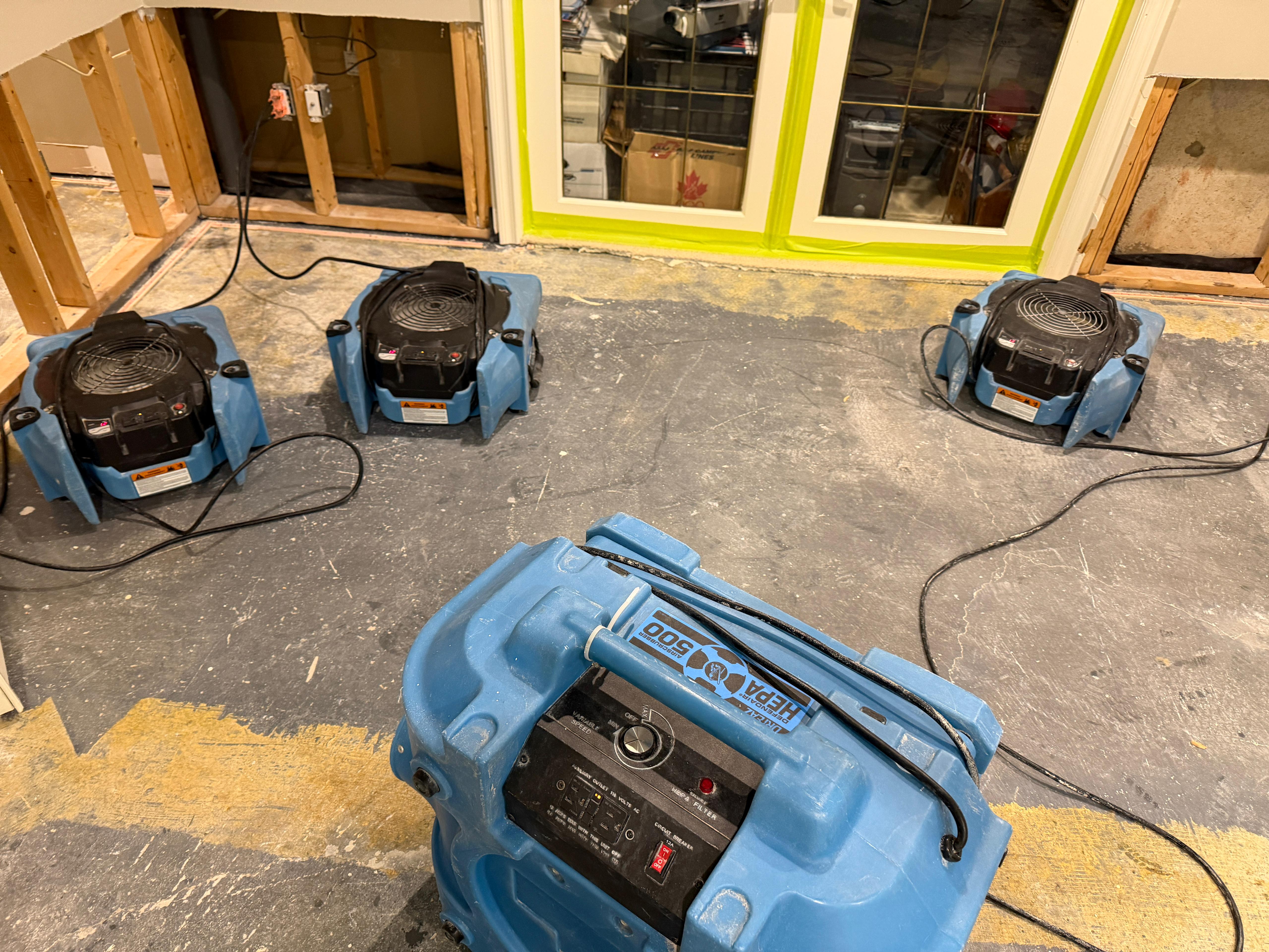 HEPA 500 air scrubber and commercial air movers deployed in a stripped Scarborough basement during water damage restoration — Restoration Professionals