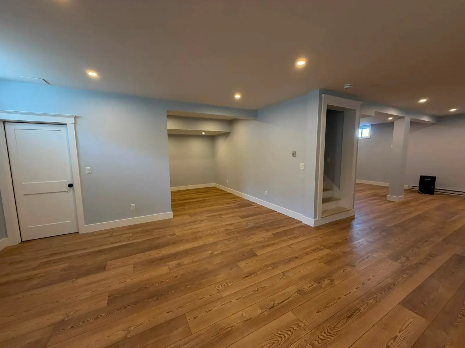 Fully restored Scarborough basement after water damage repair, new flooring and freshly painted walls