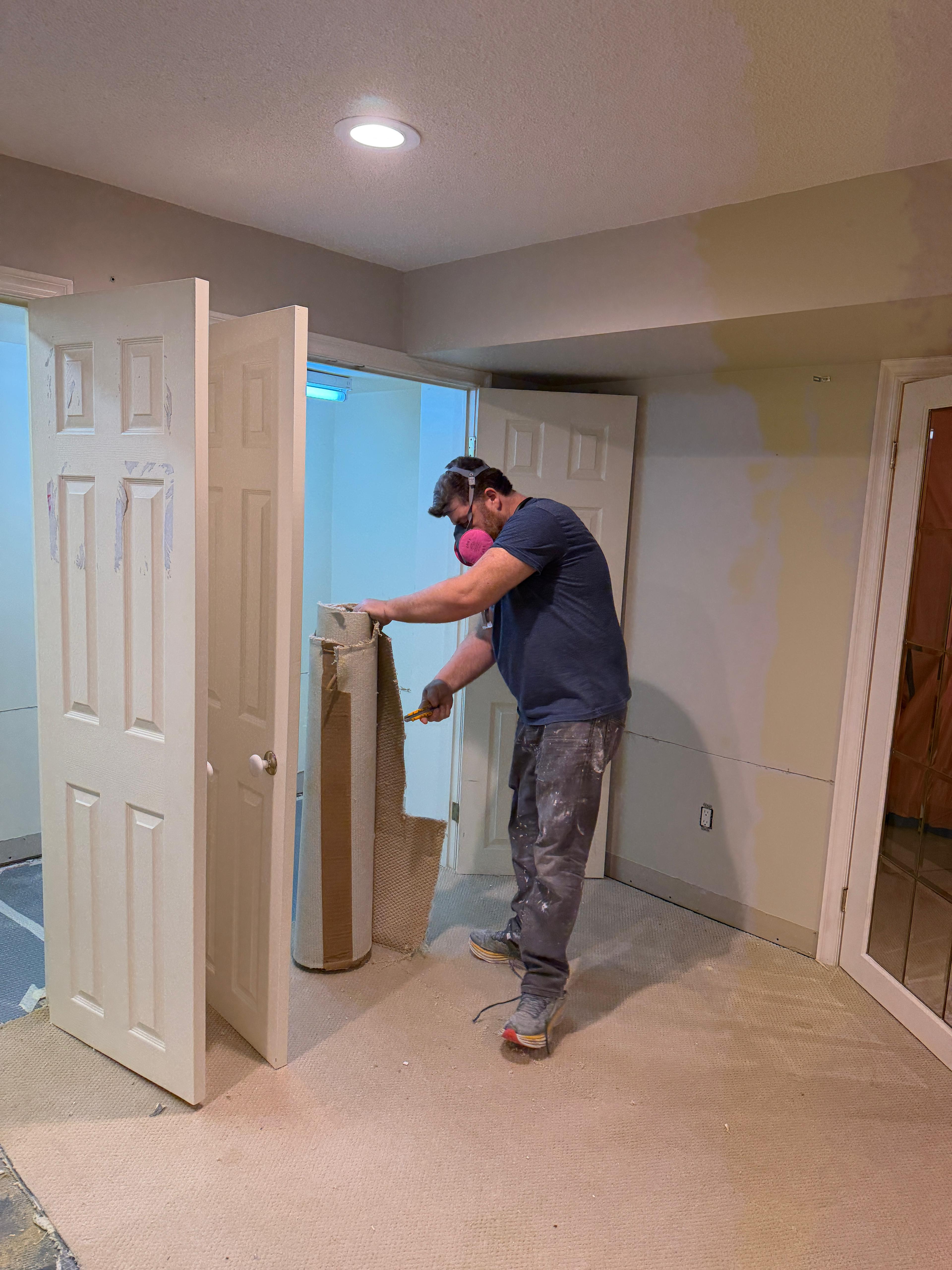 Water damage restoration technician removing water-damaged carpet from a Scarborough basement — Restoration Professionals at 85 Ellesmere Rd